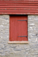 Obraz na płótnie Canvas Red shutter on beautiful stone building