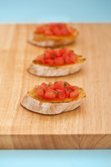 Three prepared Bruschetta on a wooden board