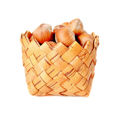 Basket with hazelnuts on white background