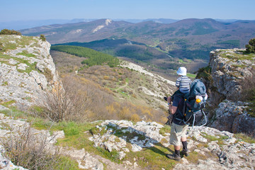 Fototapeta premium Father is hiking with the 1.5 year baby in baby carrier