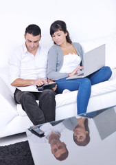 joyful couple relax and work on laptop computer at modern home