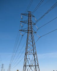 Electricity transmission power lines against a blue sky (High voltage tower). low angle view