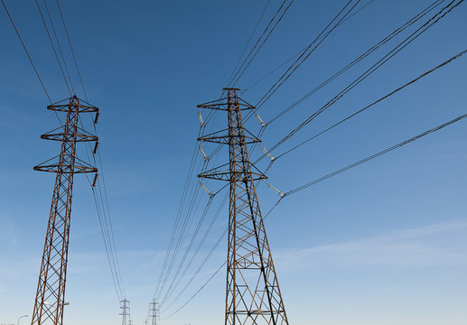 Electricity transmission power lines against a blue sky (High voltage tower). low angle view