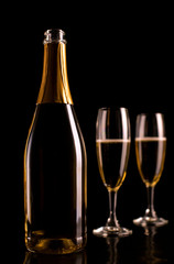 Champagne glasses and bottle on black background. New Year celeb