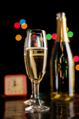 Champagne glasses and bottle on bokeh background. New Year celeb