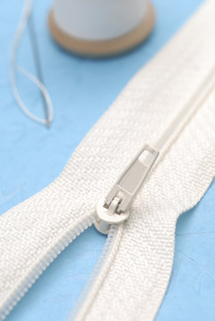 fermeture eclair et bobine de fil avec aiguille