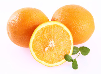 Oranges, one cut in half, on white background