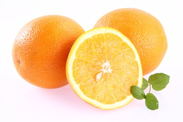 Oranges, one cut in half, on white background