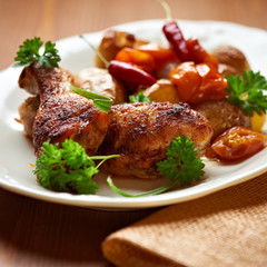 Roasted chicken legs and vegetables on a plate