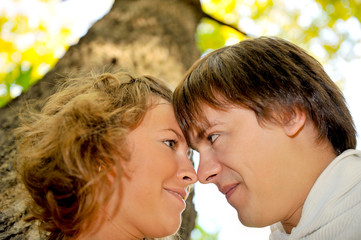 Loving couple staring at each other under the tree