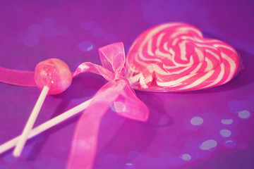 heart lollipop with pink ribbon and bokeh overlay