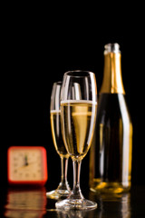 Champagne glasses and bottle on black background. New Year celeb