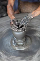 Poster Hands of a potter, creating an earthen jar on the circle © Zzvet