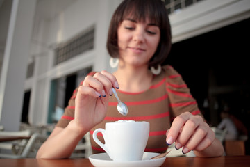 young woman stirring coffee