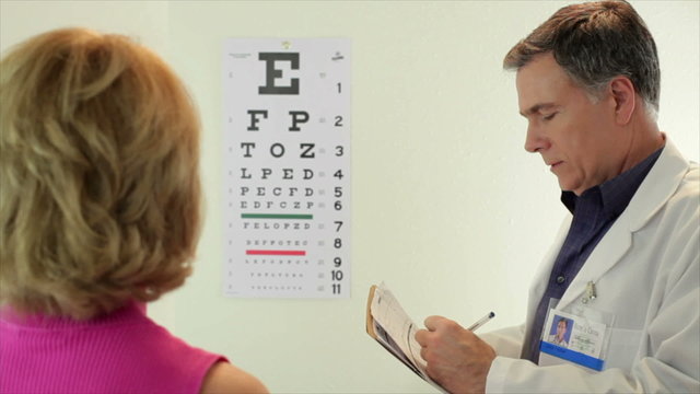 Optometrist having his patient read eye chart