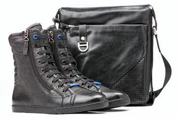 Naklejka premium Pair of black ankle-high men boots and shoulder bag
