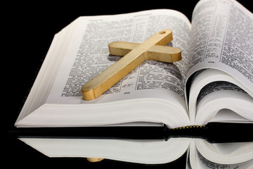 Russian bible and wooden cross on black background