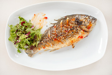 fried fish with fresh herbs and lemon