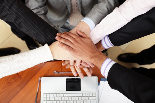 Image of business people hands on top of each other
