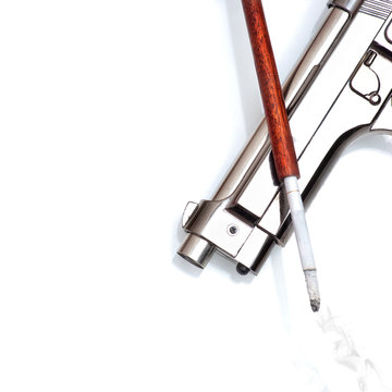Silver handgun and cigarette in cigarette holder