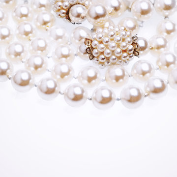 Pearl necklace fragment over white background