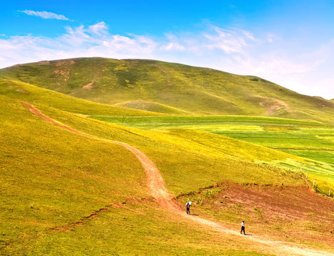 Landscape Photo Of Pepole Walking Along A Road In Plain And Hill