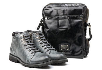 Naklejka premium Pair of men grey boots and shoulder bag over white