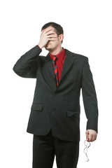 Businessman covers his eyes with one hand