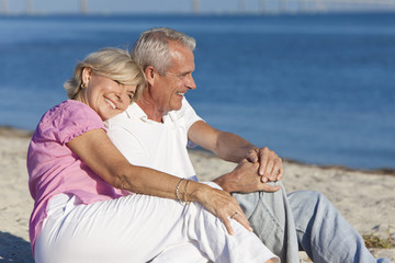 Happy Romantic Senior Couple Sitting Together on Beach