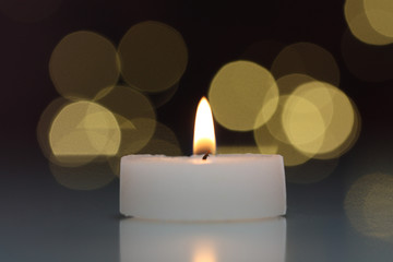 Kerze mit Lichtreflexen im Hintergrund