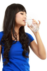 Beautiful young girl drinks water from glass