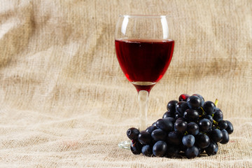 Red wine and grapes on vintage background