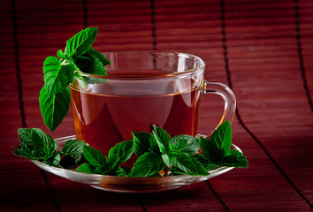 Cup of fragrant tea with fresh leaves of green tea