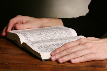 Reading open russian holy bible on wooden table