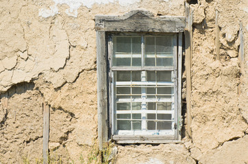 Window of an old Ukranian ruined clay-walled hut.