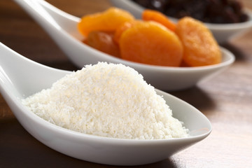 Coconut flakes on ceramic spoon