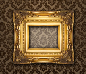 Ornamental gold frame on a damask wallpaper