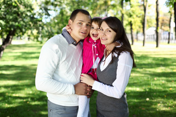 Obraz premium Young family with a child in summer park