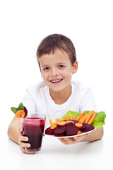 Healthy child with fresh beetroot juice and vegetable slices