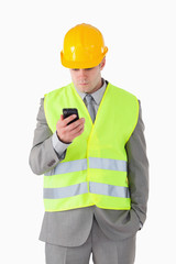 Portrait of a young builder looking at his cellphone