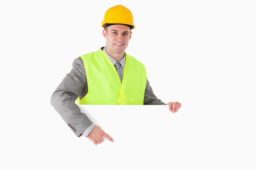 Smiling builder pointing at something