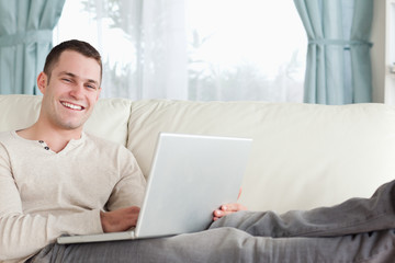 Smiling man relaxing with a notebook