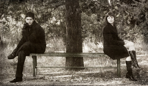 Two sitting at bench.
