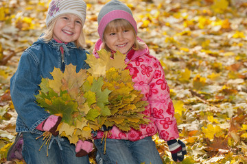 Smiling little girls with autumn leaves