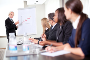 Business man explaining to his team sales team