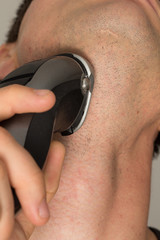 Man shaving face with electric razor