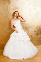 Fototapeta na wymiar Beautiful red haired woman in white bridal dress