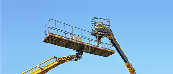 Two mobile platforms elevated towards a blue sky