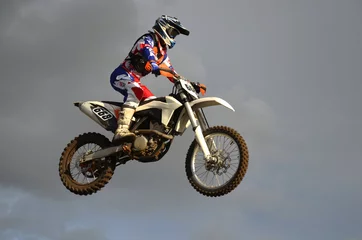Foto op Canvas The spectacular jump motocross racer on a motorcycle © VVKSAM