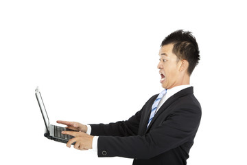 surprised young businessman watching and holding laptop